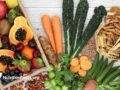 Plant foods high in fiber with whole wheat pasta, nuts, fruit and vegetables on a rustic background